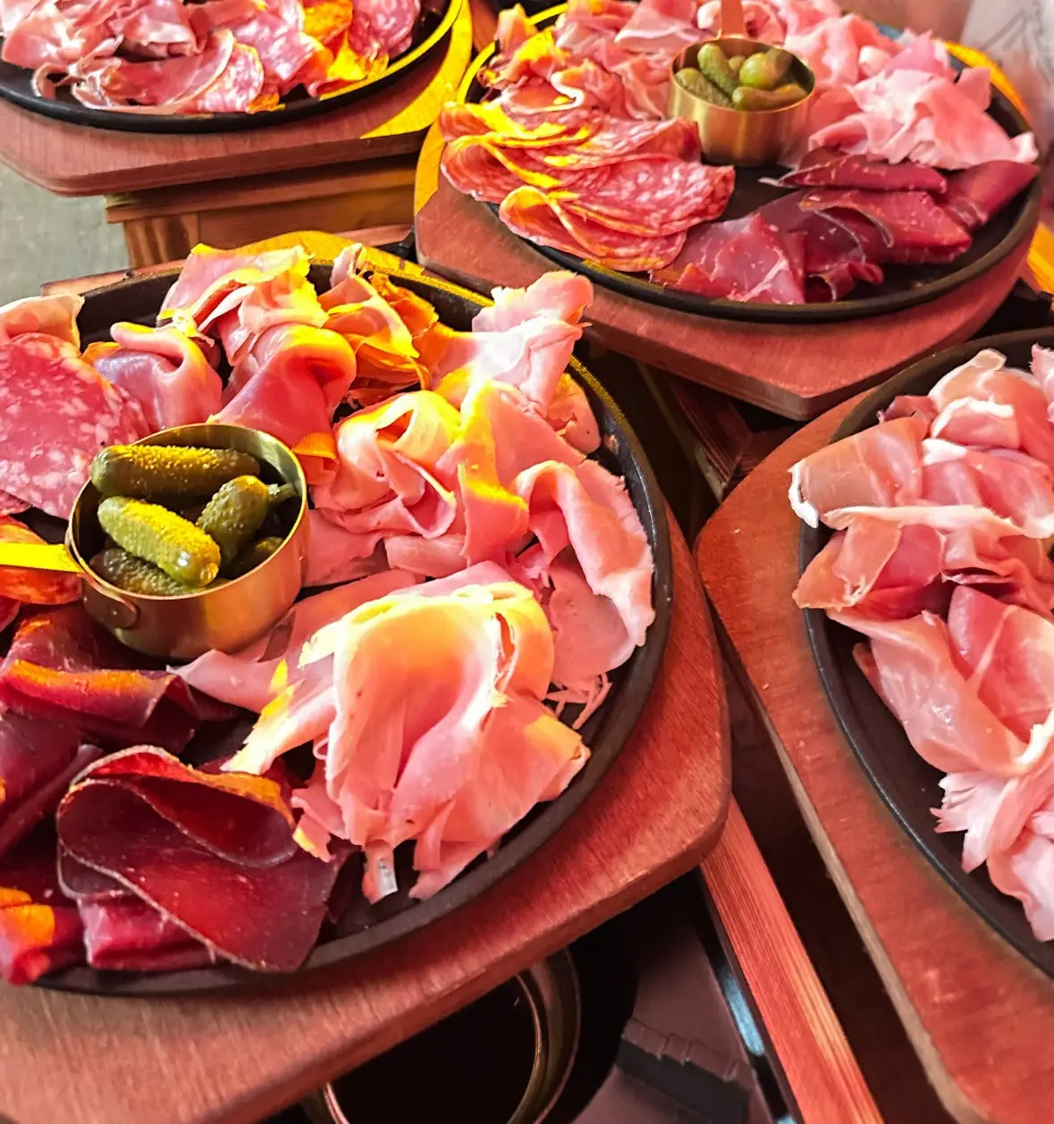 Planches de charcuteries dressées sur des ardoises, jambon, coppa et cornichons