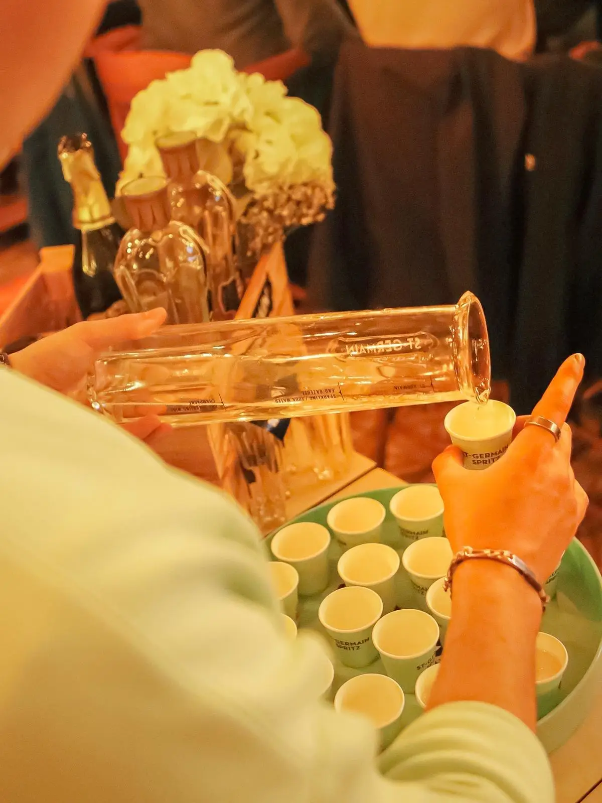 Service de spritz St-Germain en petits gobelets, versés à la carafe pendant une soirée