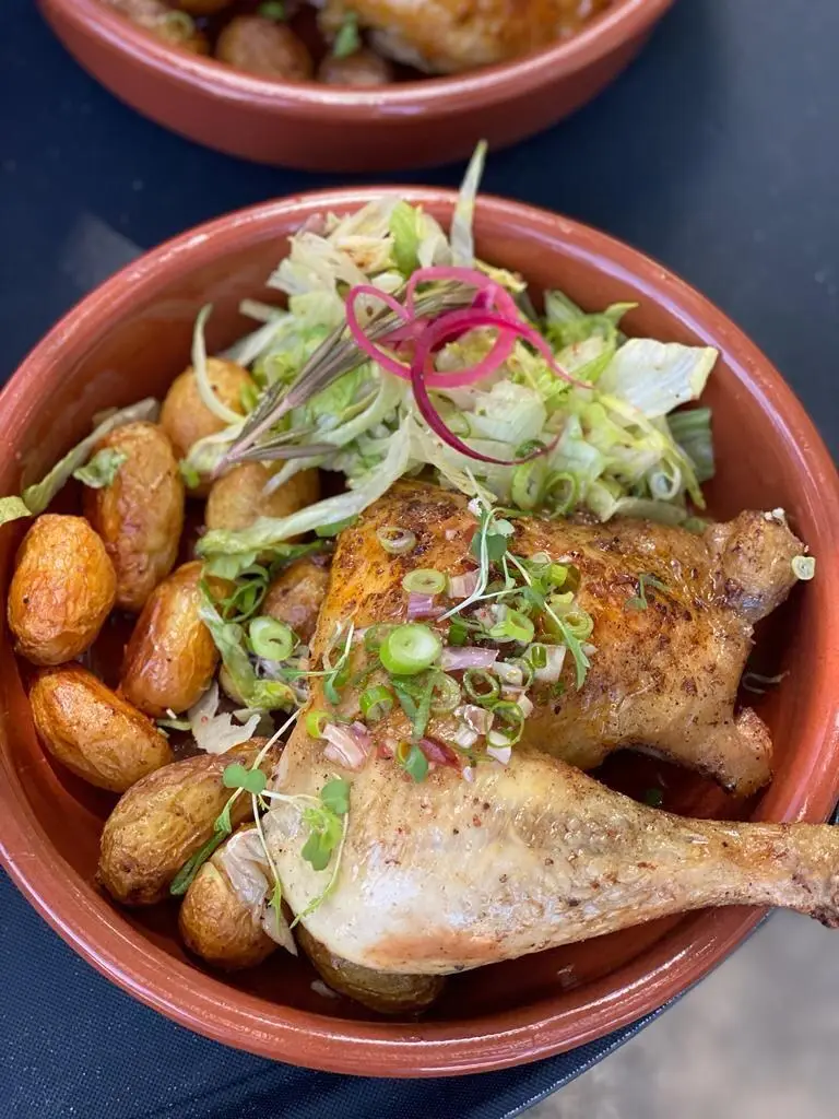 Cuisse de volaille rôtie et pommes grenaille dans une cassolette en terre cuite, salade croquante